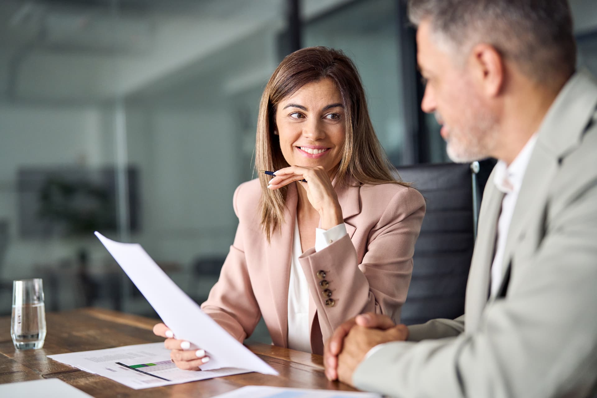 Two advisors reviewing deal documents across a desk